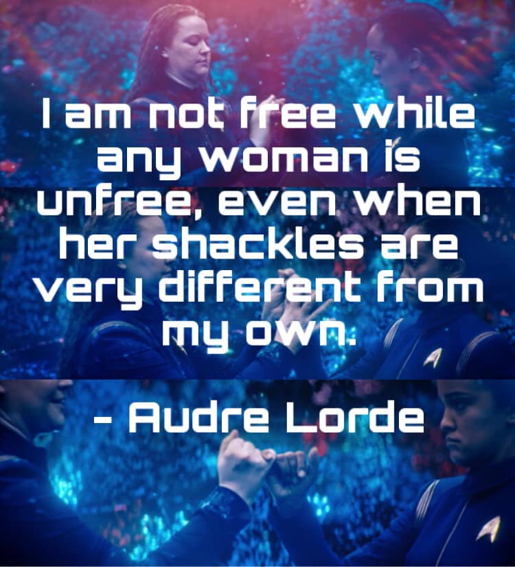 The meme features a screenshot of a scene from the TV show Star Trek: Discovery, specifically a moment where the character of Lt. Commander Asha Ty, played by Sonequa Martin-Green, is embracing her identity as a Starfleet officer and as a Black woman. The meme is captioned with a quote from the book "The Miseducation of a Black Woman" by Audre Lorde, which reads: "I am not free while any woman is unfree, even when her shackles are very different from mine."